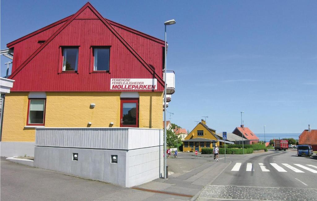 a red and yellow building on the side of a street at Mlleparken in Gudhjem