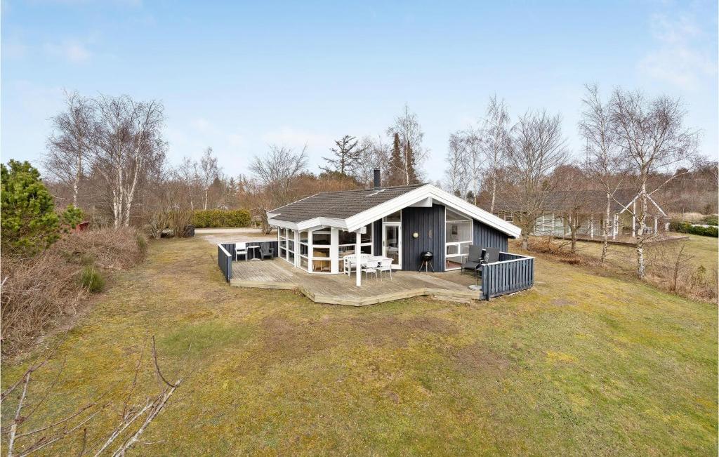 a small house in a field with a yard at Nice Home In Grenaa With Kitchen in Stokkebro
