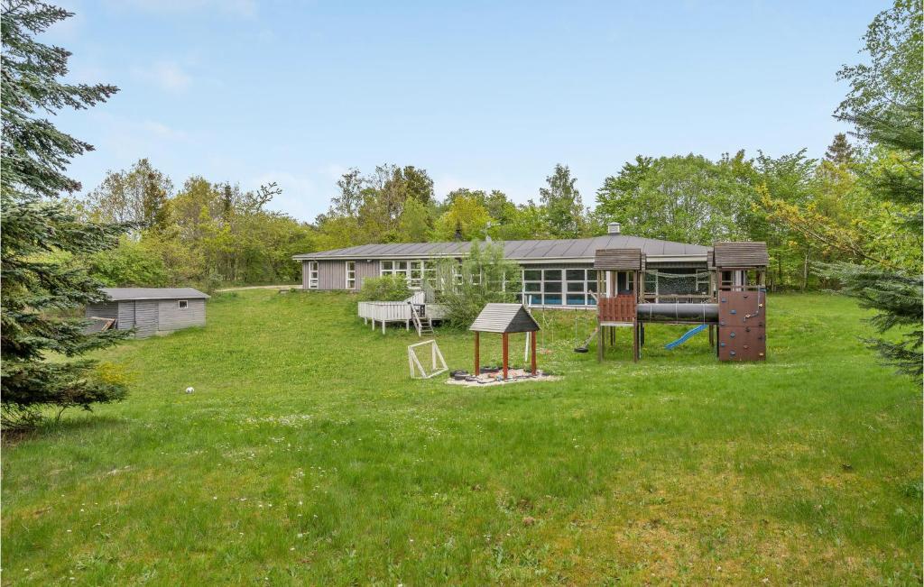 a yard with a playground and a house at Nice Home In Ebeltoft With Sauna, Wifi And Indoor Swimming Pool in Ebeltoft