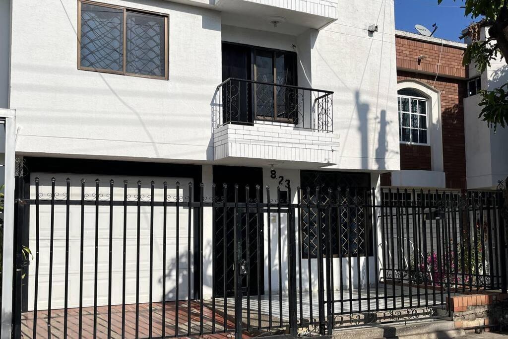 een wit huis met een smeedijzeren hek bij Casa Salmón Confortable Casa Completa in Valledupar
