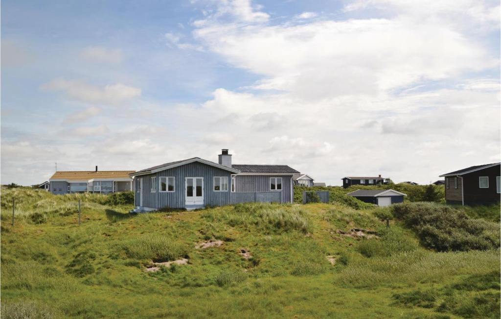 une maison au sommet d'une colline herbeuse avec des maisons dans l'établissement Karin, à Fanø