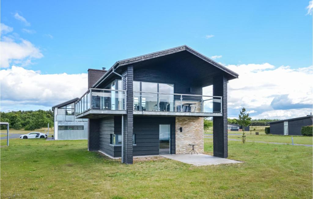 a house with a balcony on top of a field at Amazing Home In Nimtofte With Wifi in Nimtofte