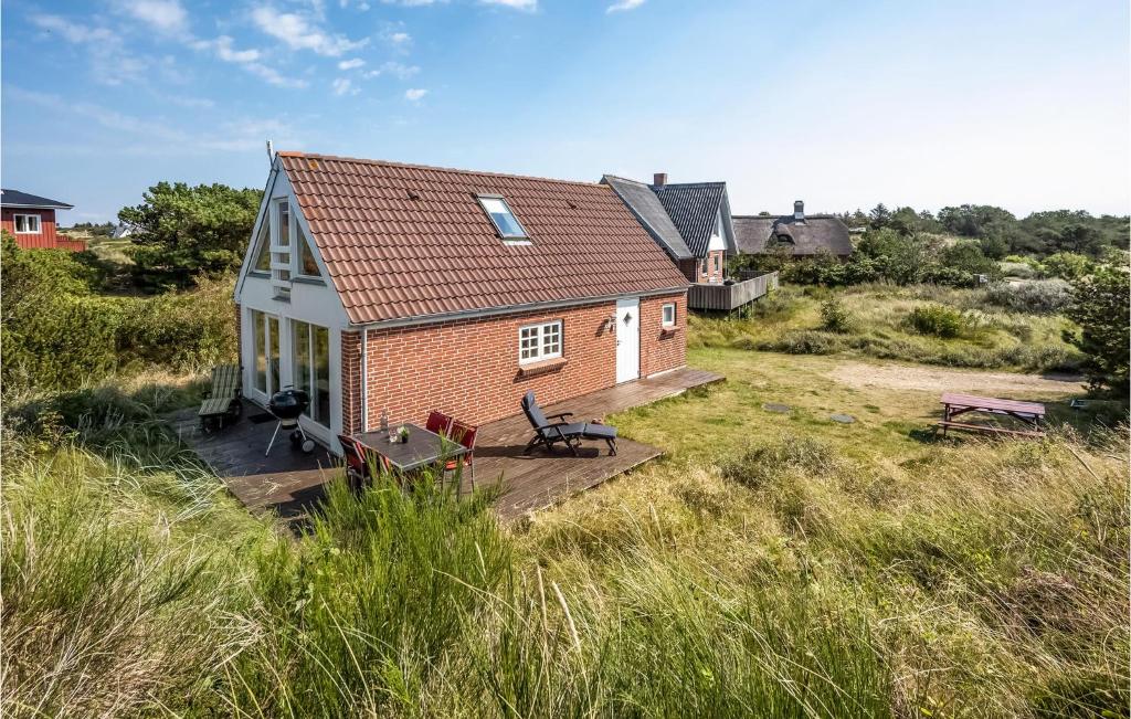 a small house with a deck in a field at Awesome Home In Nrre Nebel With Kitchen in Nymindegab