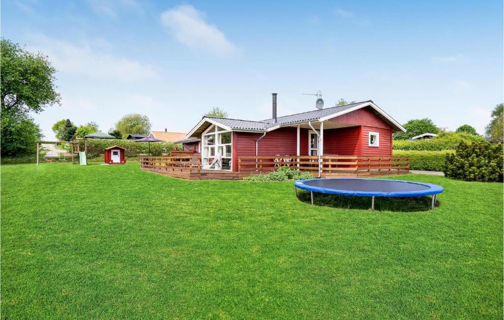 een rood huis met een blauwe trampoline in de tuin bij Awesome Home In Hejls With 4 Bedrooms, Sauna And Wifi in Hejls