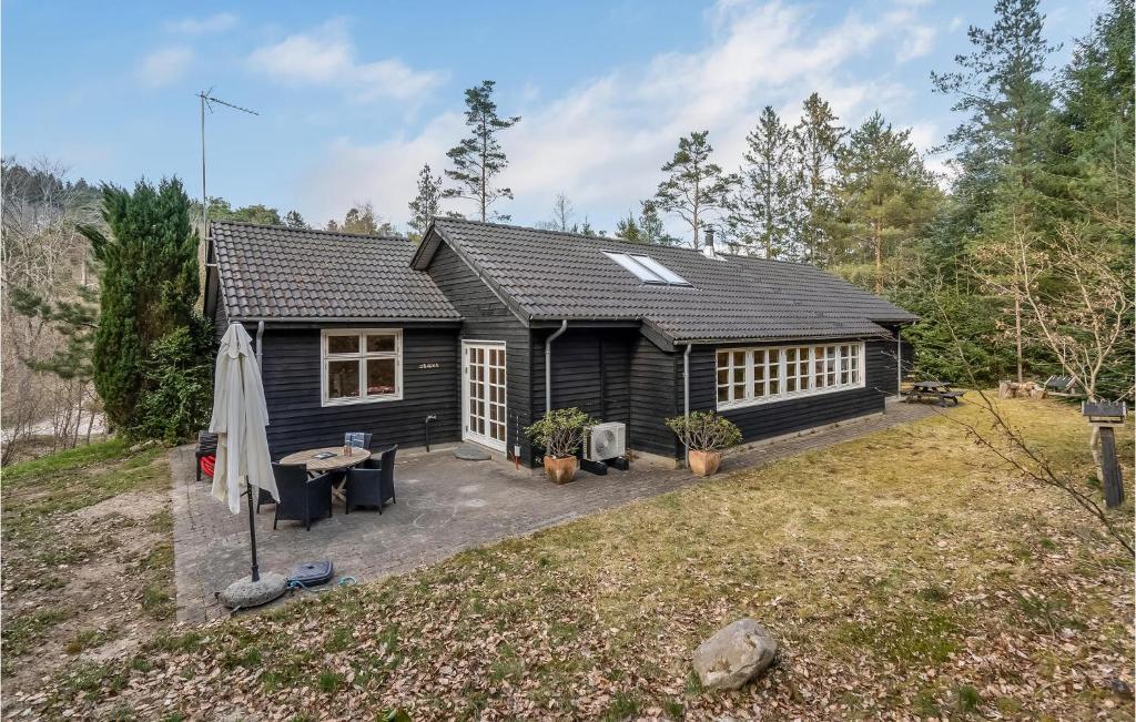 a black cabin with a table and a patio at 3 Bedroom Cozy Home In Silkeborg in Silkeborg