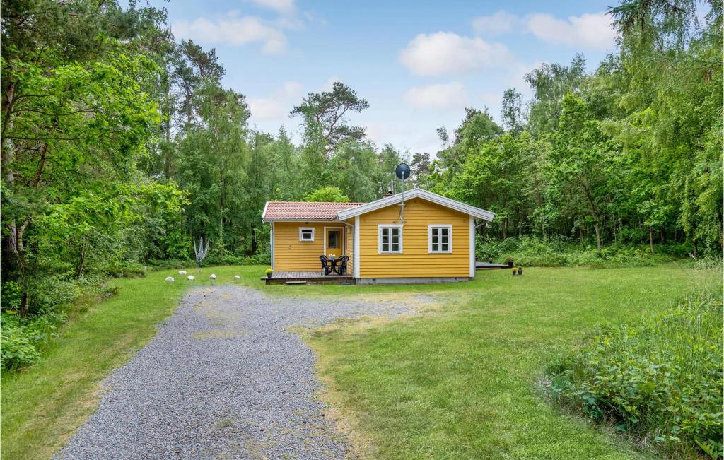 una pequeña casa amarilla en medio de un campo en Baluka, en Bedegård