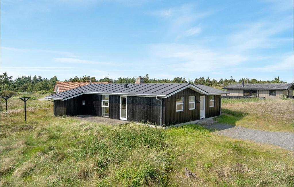 Bjerregårdにある3 Bedroom Amazing Home In Hvide Sandeの畑の黒屋根の家