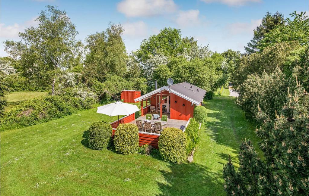 una pequeña casa roja con una sombrilla en un campo verde en Paradiset en Skattebølle
