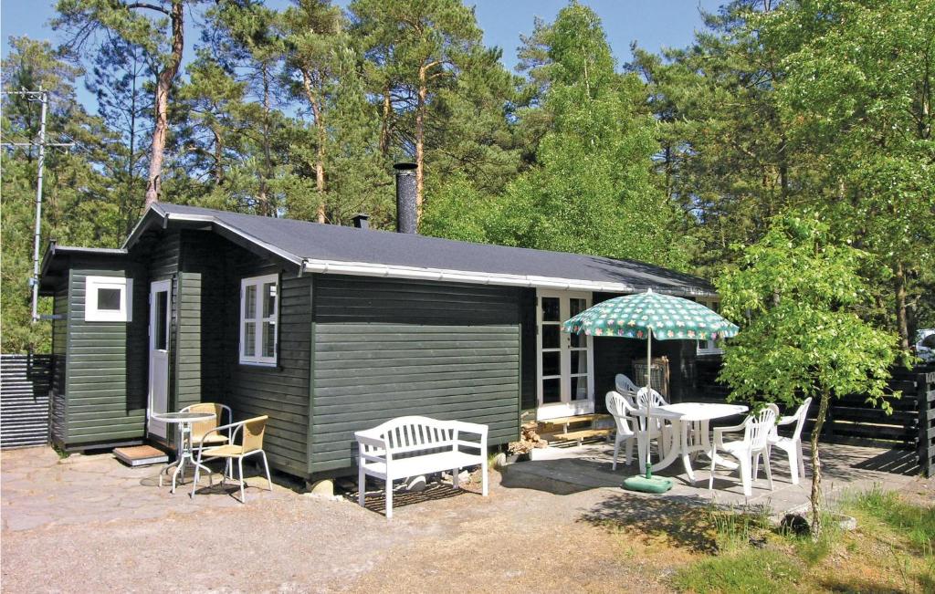 a small green cabin with chairs and an umbrella at Stunning Home In Nex With 2 Bedrooms And Wifi in Spidsegård