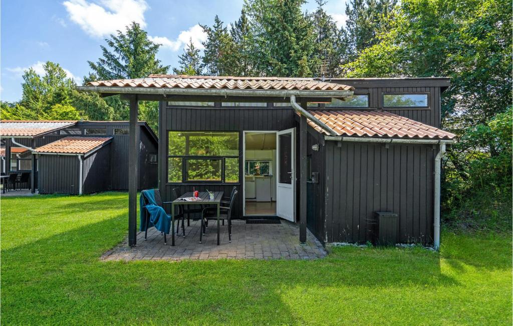 ein schwarzer Schuppen mit einem Tisch im Gras in der Unterkunft Lovely Home In Hampen With Kitchen in Hampen