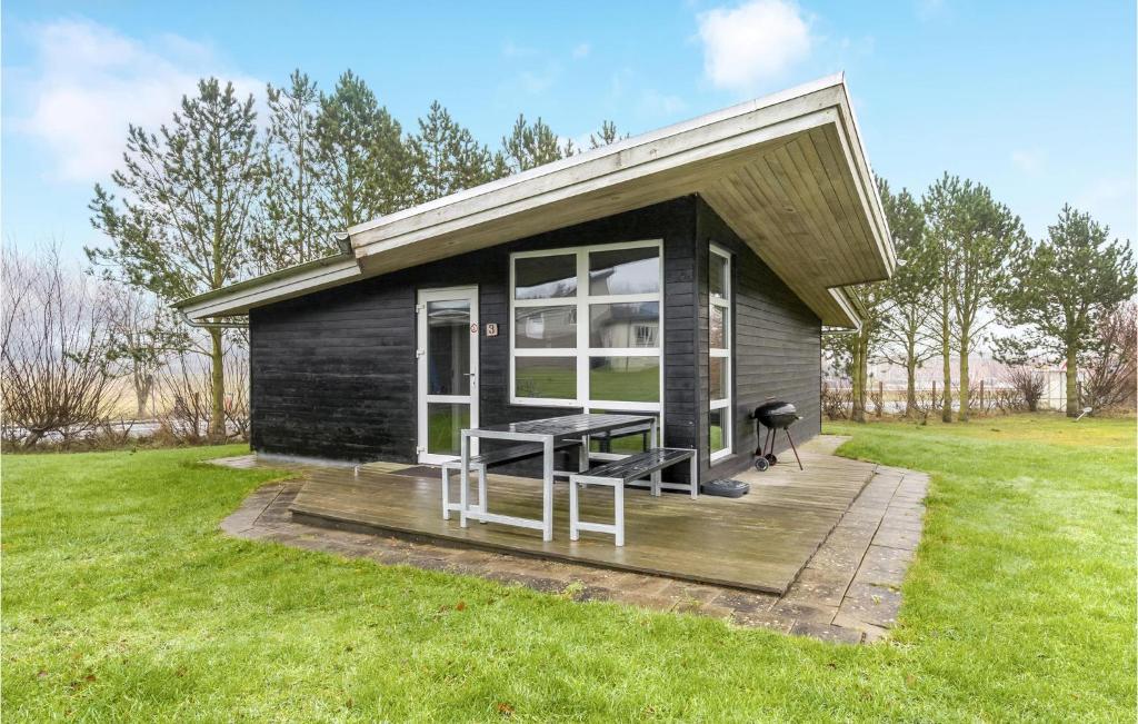 a tiny house with a picnic table on a deck at 2 Bedroom Amazing Home In Roslev in Sallingsund