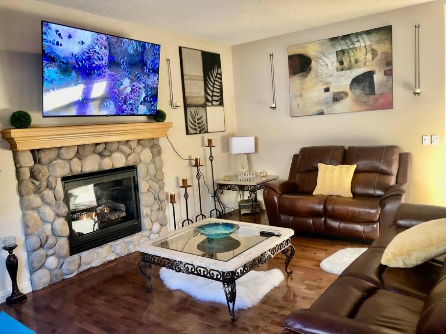 a living room with a couch and a fireplace at 2500 sq house in Springbank Hill BL 261818 in Calgary