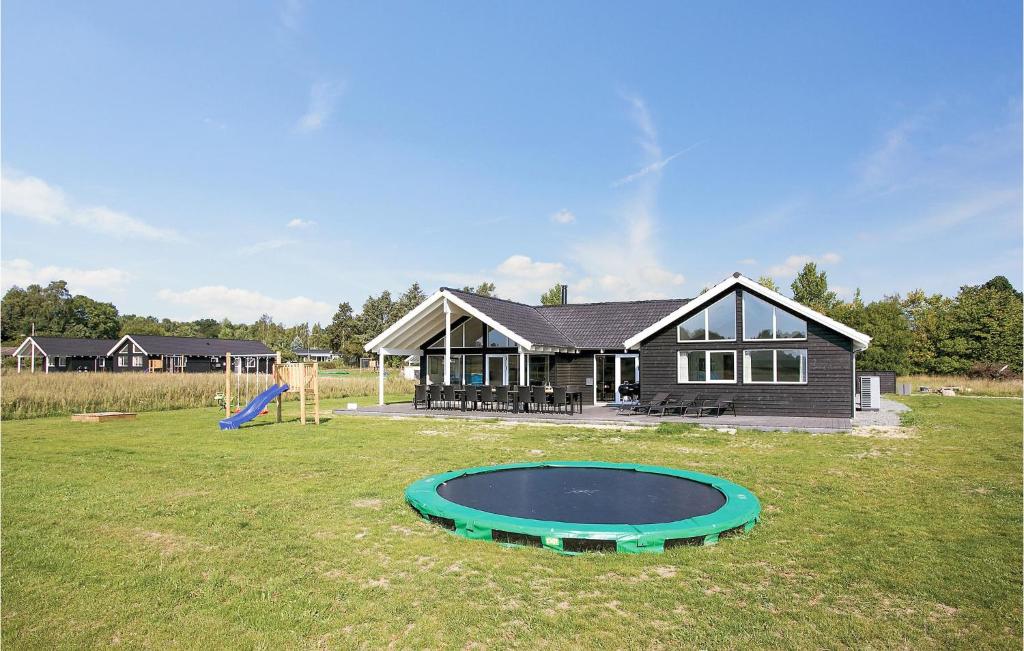 a house with a playground and a trampoline in the yard at Cozy Home In Vejby With Indoor Swimming Pool in Vejby