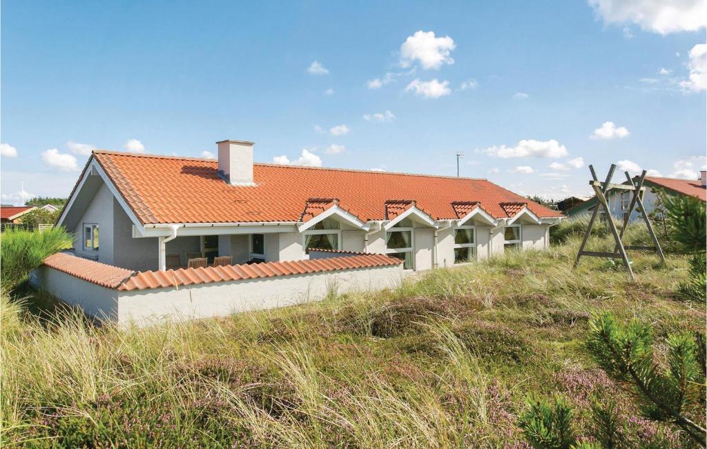 a house with an orange roof on top of a field at Beautiful Home In Thisted With 3 Bedrooms, Sauna And Wifi in Klitmøller