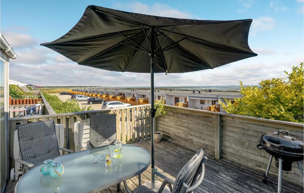 une table avec un parasol sur une terrasse dans l'établissement Cozy Apartment In Rm With Kitchen, à Rømø Kirkeby