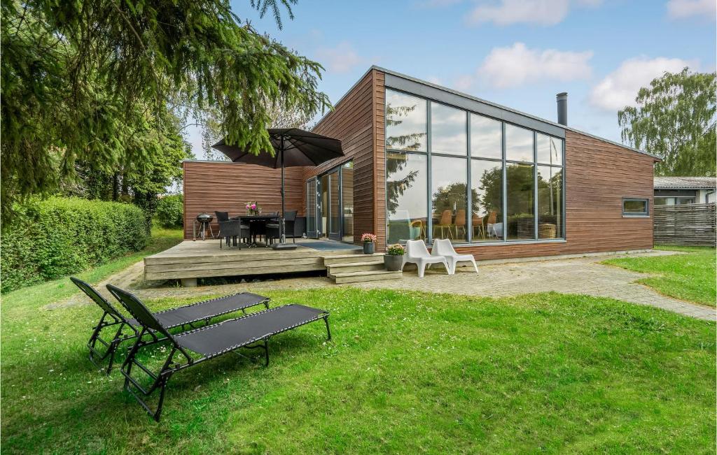 エーベルトフトにあるBeautiful Home In Ebeltoft With 5 Bedrooms And Wifiの芝生のベンチ付き家