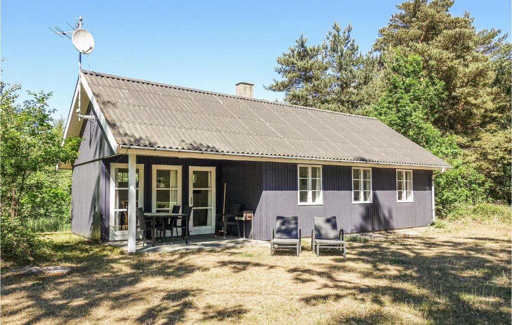 uma pequena casa com duas cadeiras em frente em Pet Friendly Home In Aakirkeby With Kitchen em Vester Sømarken