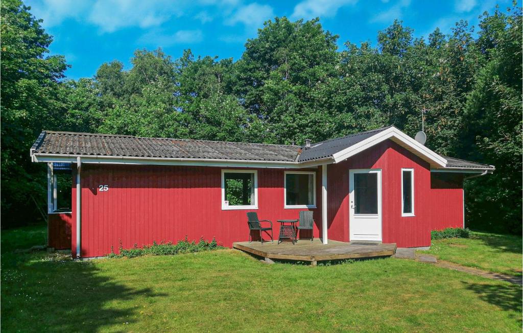 czerwony domek z tarasem w ogrodzie w obiekcie 3 Bedroom Gorgeous Home In Oksbl w mieście Oksbøl