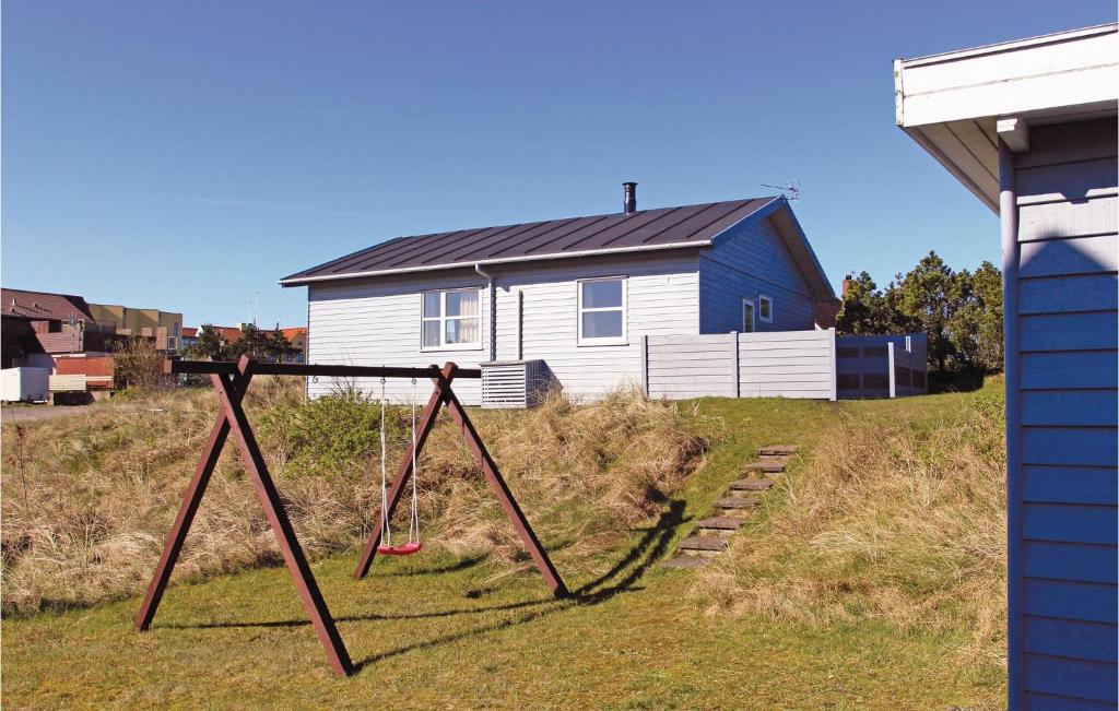 a yard with a swing set in front of a house at Holiday Home Nørre Nebel 59 in Nymindegab