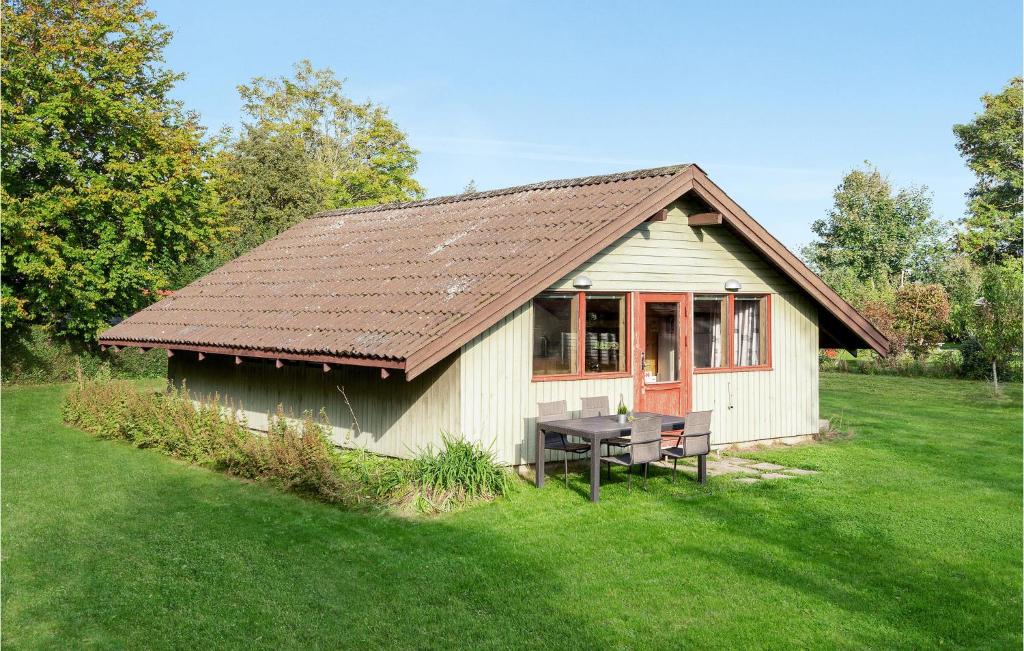 a small house with a picnic table in the grass at Amazing Home In Kirke Hyllinge With Kitchen in Sæby