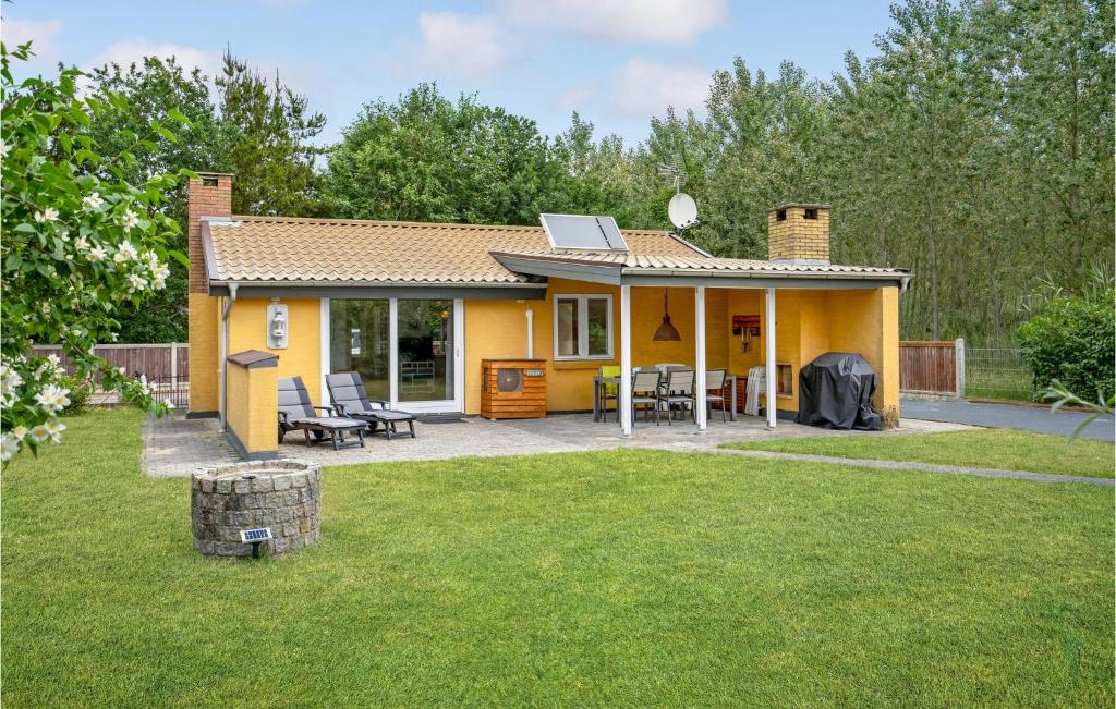 Fjellerup StrandにあるNice Home In Glesborg With 3 Bedrooms And Wifiの小さな黄色の家 中庭にパティオ付