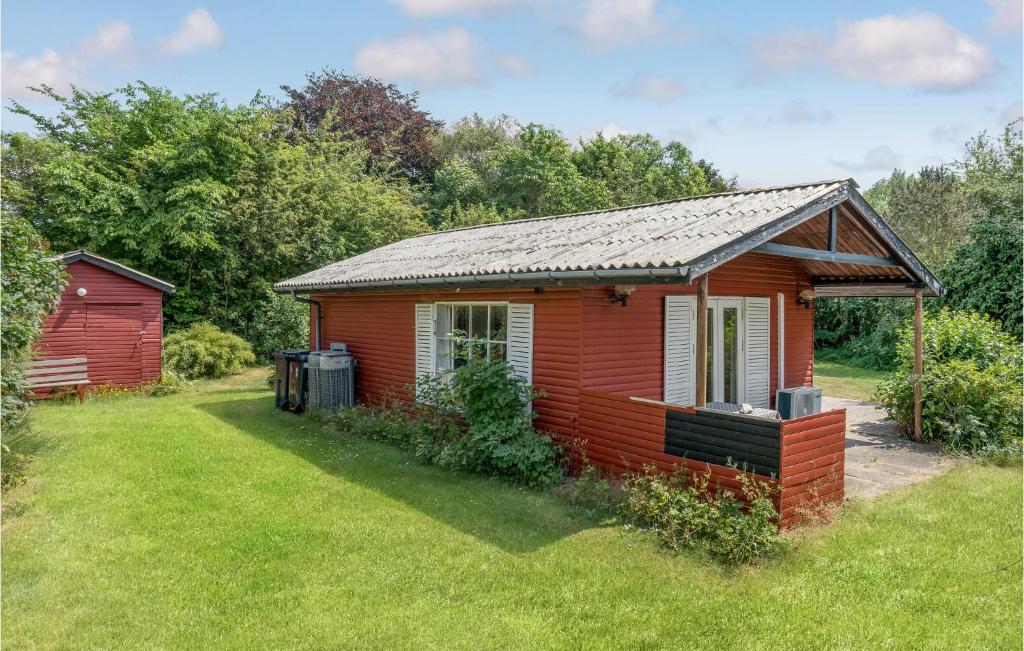 uma pequena cabina vermelha num campo de relva em Awesome Home In Fllenslev With Kitchen em Eskebjerg