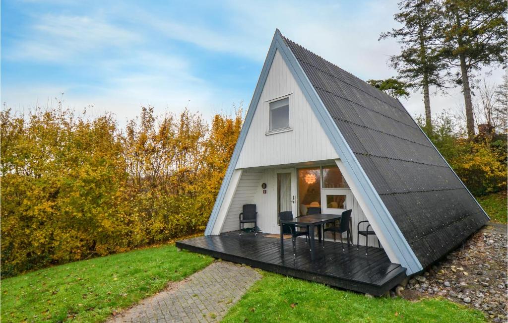 a small white house with a black roof at Studio Holiday Home In Knebel in Knebel