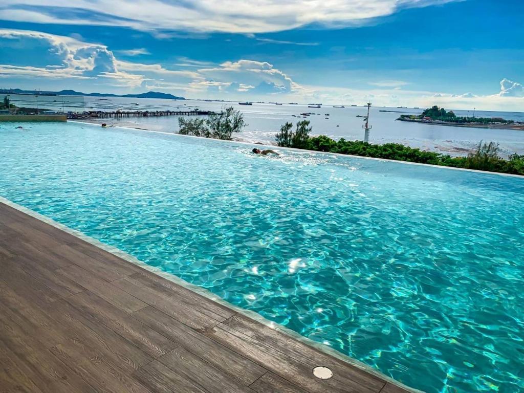 - une piscine avec vue sur l'eau dans l'établissement Oakwood Hotel & Residence Sriracha - SHA Extra Plus, à Si Racha