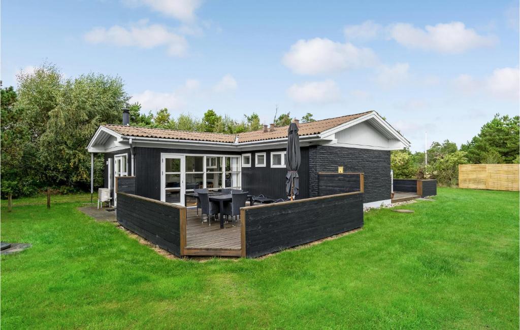 a small house with a deck in a yard at Beautiful Home In Blvand With Wifi in Blåvand