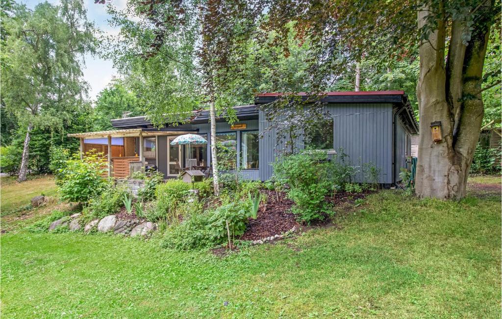 a small house in a yard next to a tree at 4 Bedroom Awesome Home In Skibby in Skibby