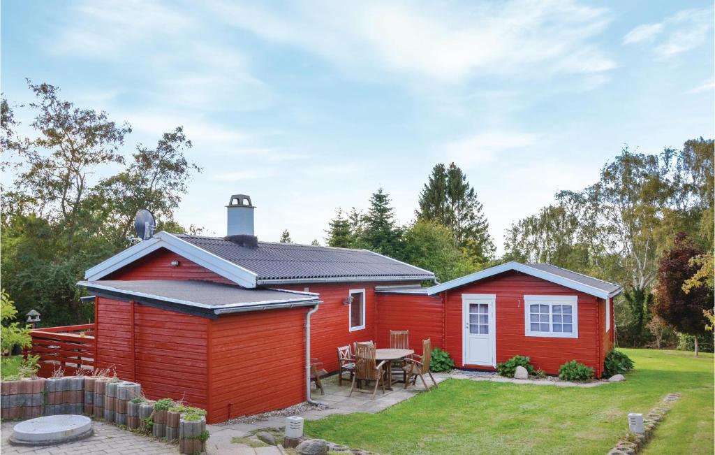 een rode hut met een tafel in een tuin bij Stunning Home In Jgerspris With Wifi in Jægerspris