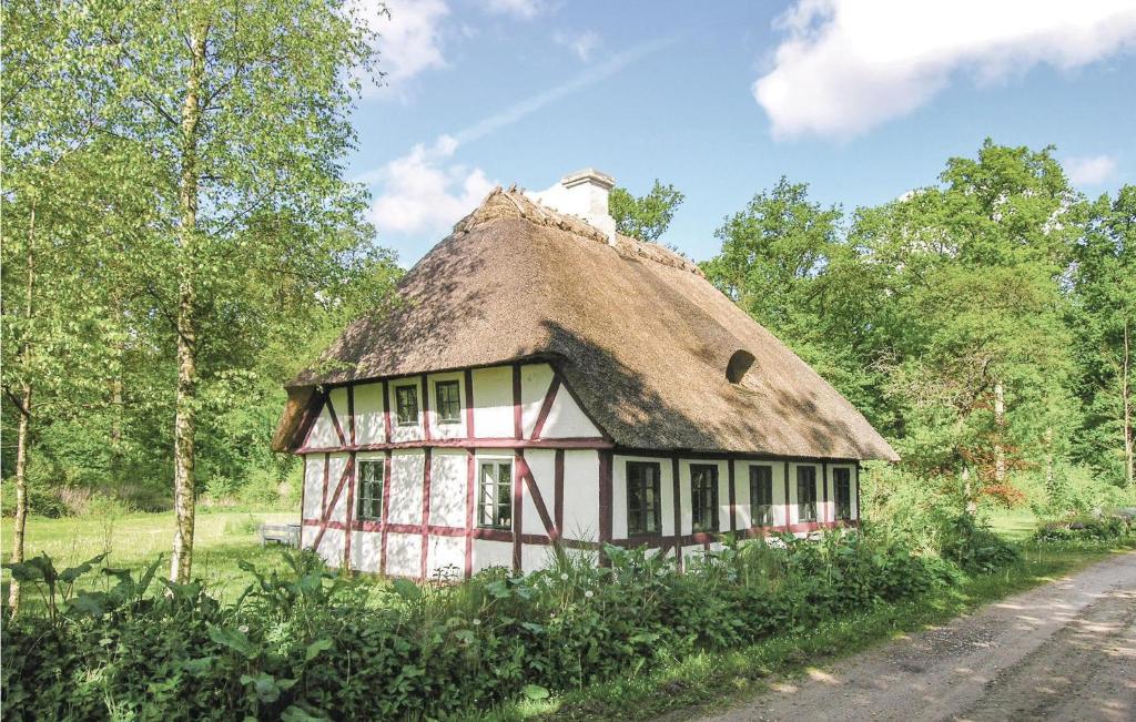una casa antigua con techo de paja en una carretera en Beautiful Home In Gudbjerg Sydfyn With Kitchen, en Gudme