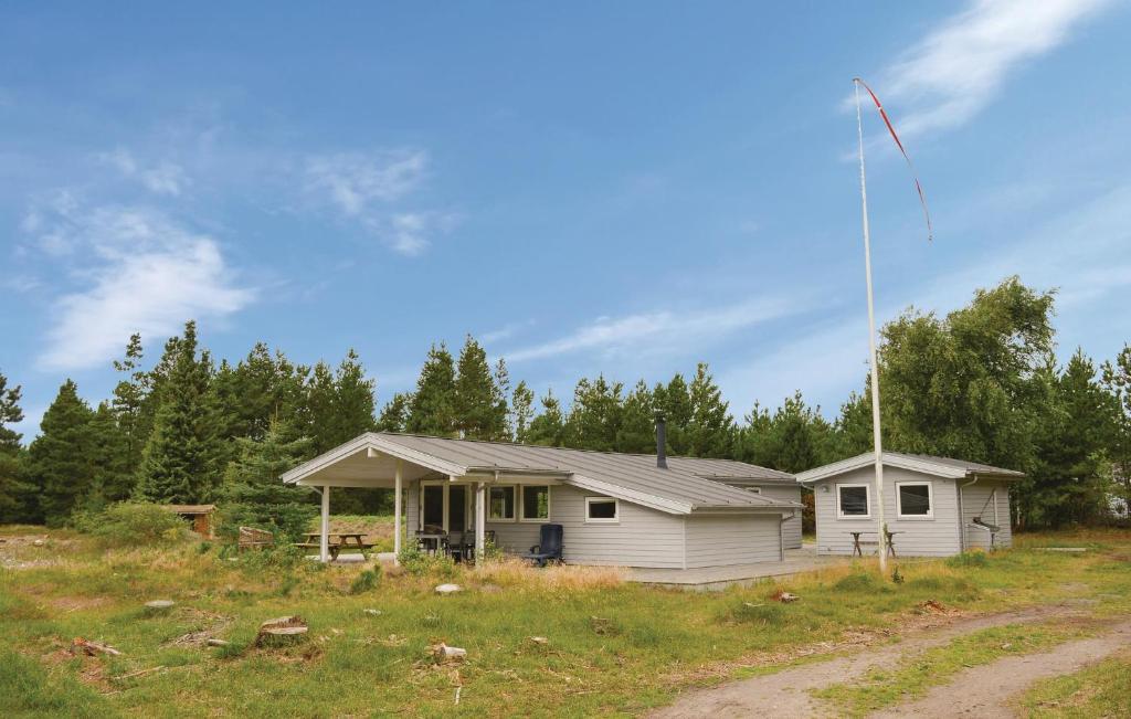 una casa con un'asta della bandiera in un campo di Holiday Home Romo With A Fireplace 333 a Rømø Kirkeby