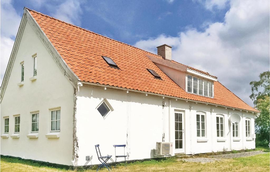 グドイェムにあるAmazing Home In Gudhjem With 4 Bedrooms And Wifiのオレンジ色の屋根の白い家