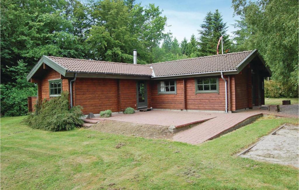 ein kleines Holzhaus mit einer großen Terrasse in der Unterkunft 3 Bedroom Stunning Home In Roslev in Roslev