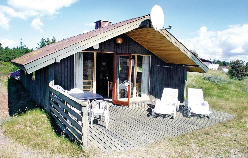 BjerregårdにあるAmazing Home In Hvide Sande With Kitchenの椅子とテーブル付きのデッキ