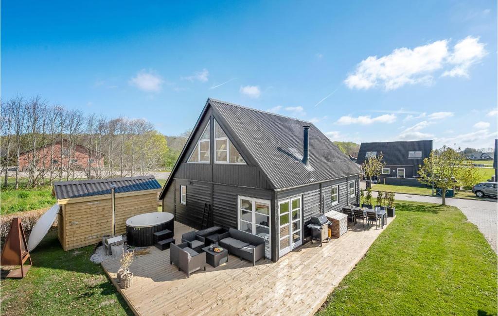 een zwart huis met een terras met een grill bij Nice Home In Fars With Kitchen in Farsø