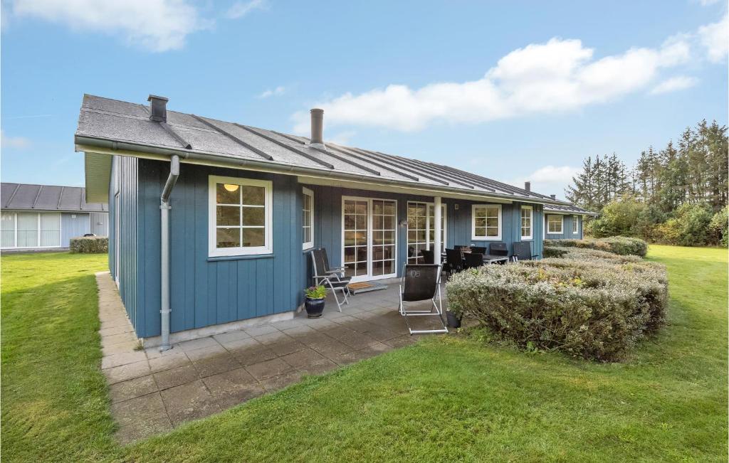 a blue house with a patio in a yard at 3 Bedroom Nice Home In Nrre Nebel in Nørre Nebel