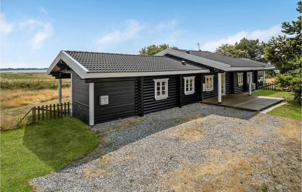 een klein zwart huis met een oprit en gras bij Nice Home In Grlev With House Sea View in Gørlev