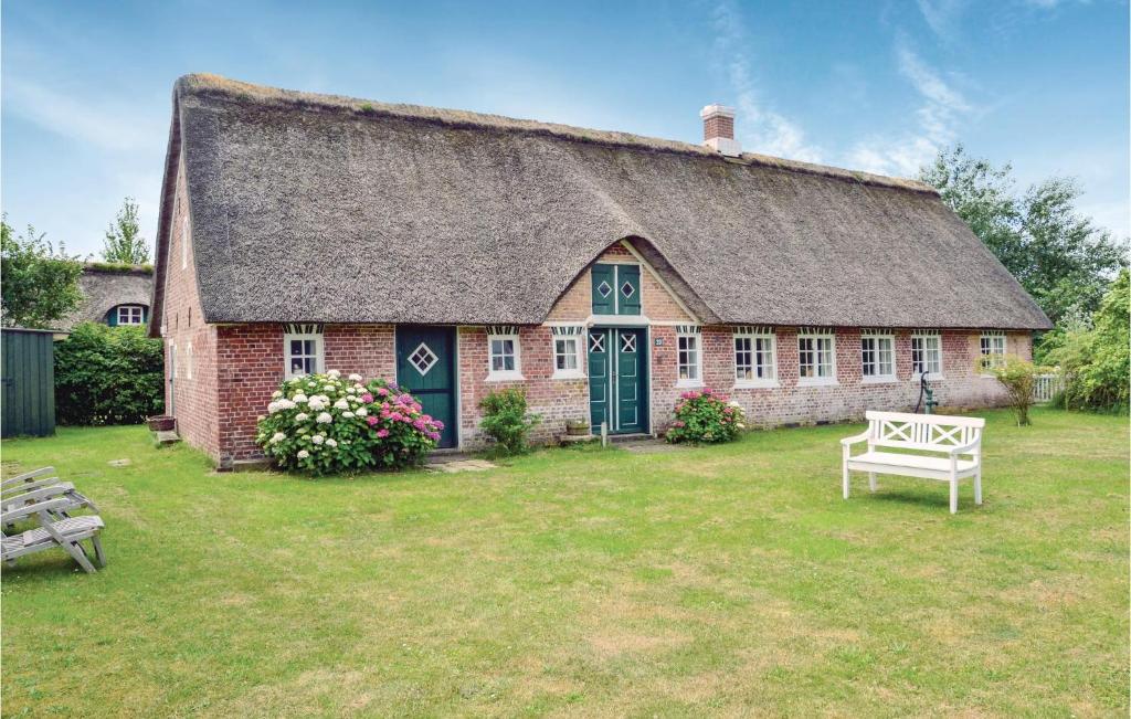 a large brick house with a thatched roof at Gorgeous Home In Fan With Kitchen in Sønderho