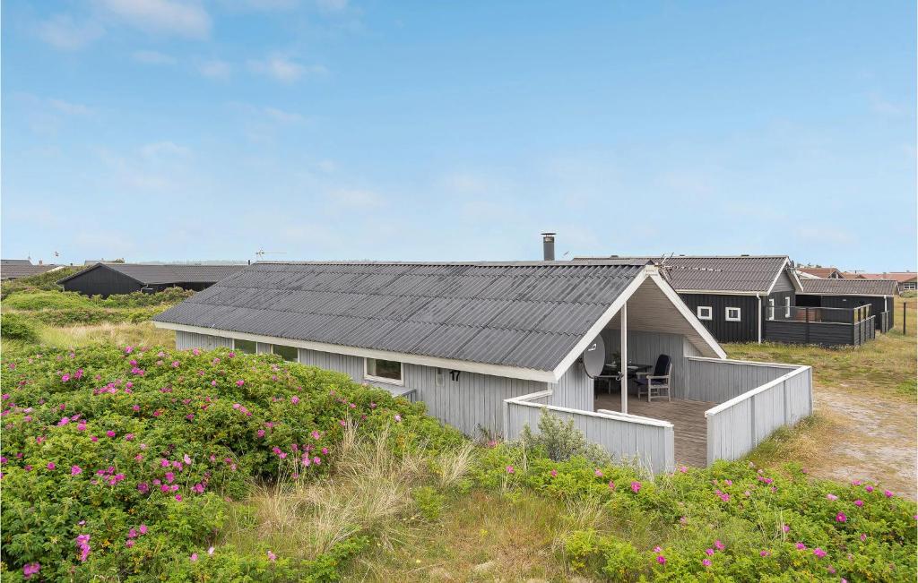 BjerregårdにあるCozy Home In Hvide Sande With Wifiの花畑黒屋根の家