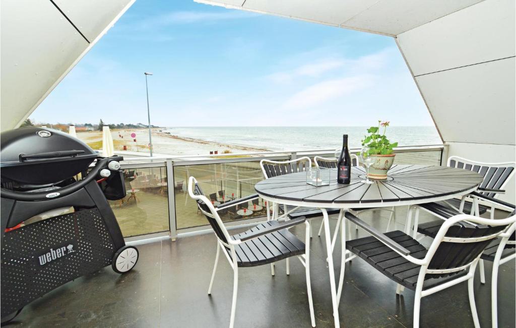 a patio with a table and chairs and the beach at Amazing Apartment In Karrebksminde With 3 Bedrooms And Wifi in Karrebæksminde