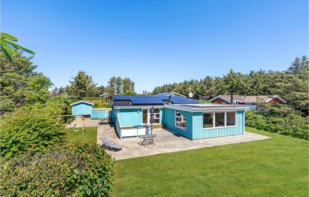 una casita azul en medio de un patio en Nice Home In Lkken With 3 Bedrooms, Sauna And Wifi, en Lønstrup