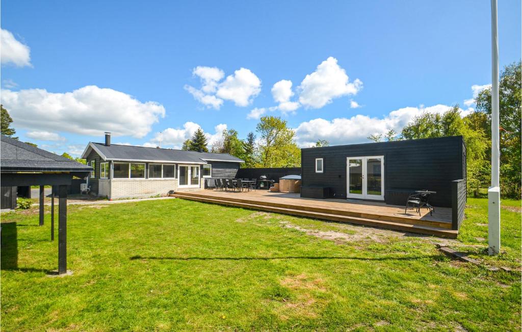 una casa negra con terraza y patio en 4 Bedroom Gorgeous Home In Vggerlse, en Bøtø By