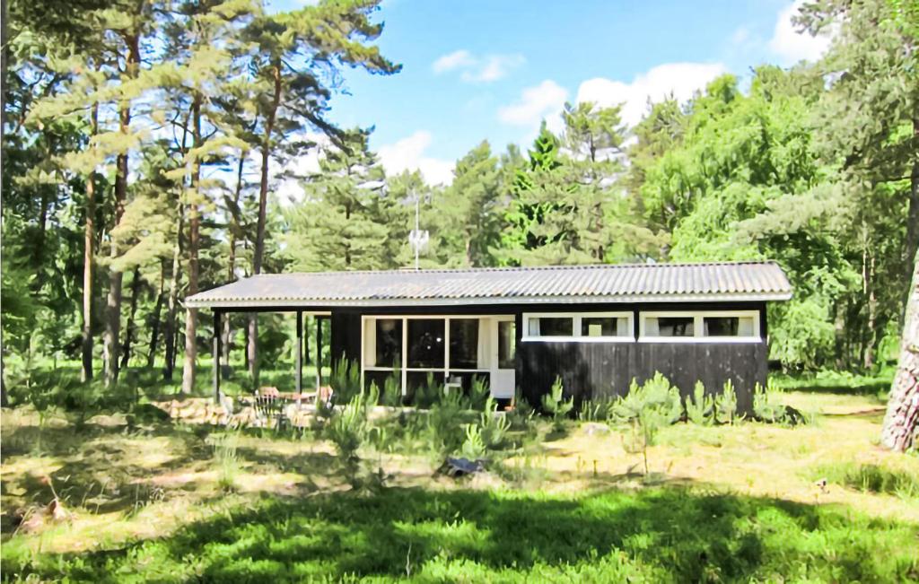 a small house in the middle of a forest at Awesome Home In Nex With Kitchen in Vester Sømarken