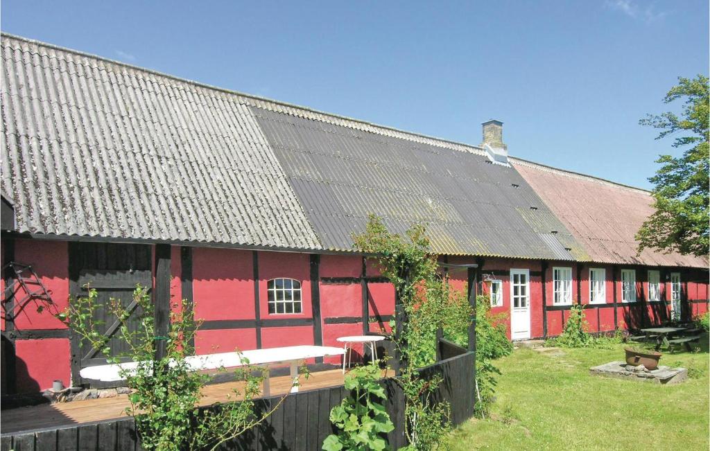 een rood huis met een zwart dak bij Stunning Home In Nex With Wifi in Spidsegård
