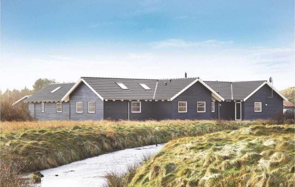 ein Haus mit Sonnenkollektoren auf dem Dach in der Unterkunft Cozy Home In Vejers Strand With Wifi in Vejers Strand