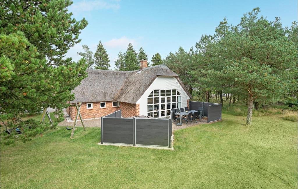 a house with a thatched roof with a patio at Four-Bedroom Holiday Home In Norre Nebel in Nørre Nebel