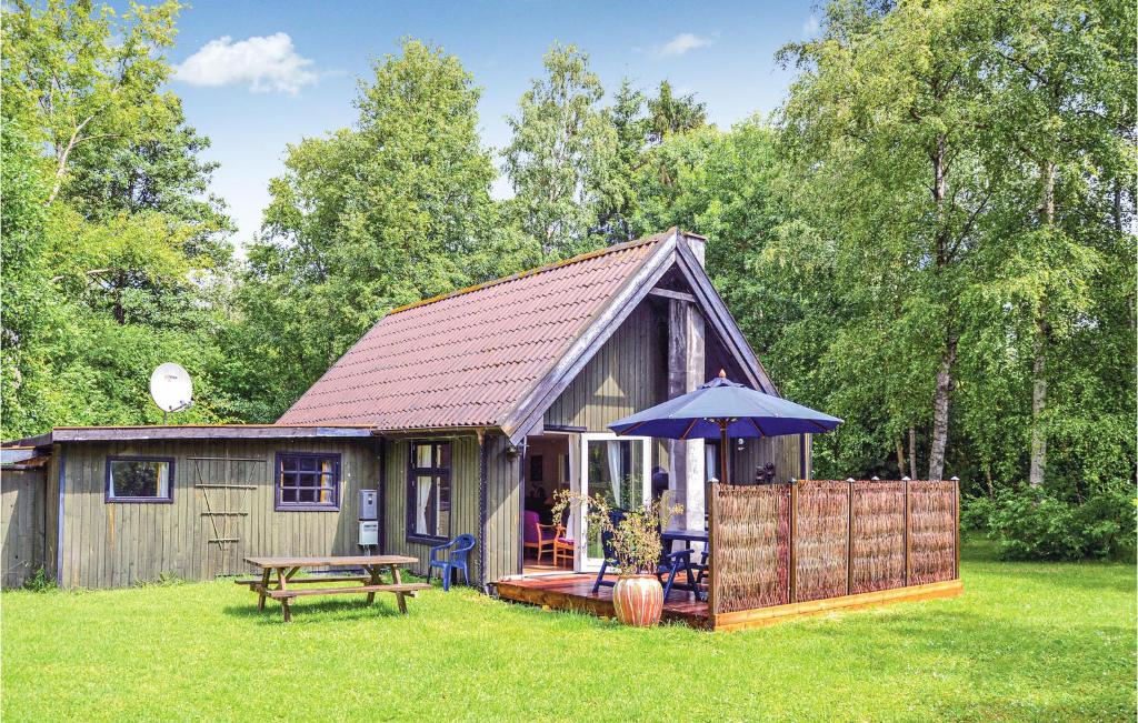 een kleine hut met een picknicktafel en een parasol bij 2 Bedroom Gorgeous Home In Frederiksvrk in Frederiksværk