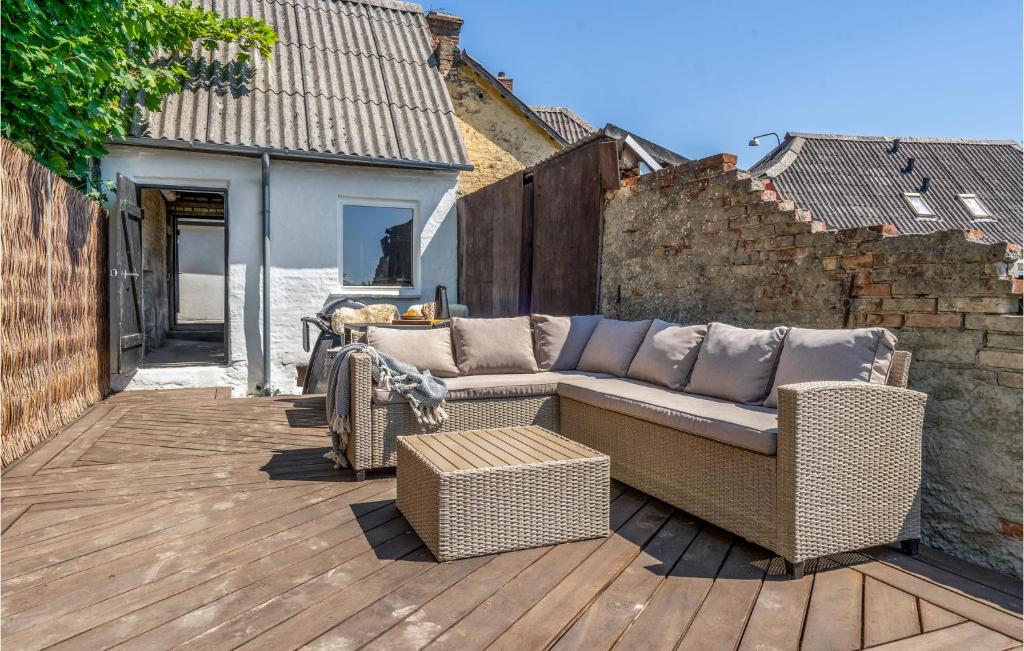 un divano in vimini seduto su una terrazza di legno di Nice Home In Svendborg With Wifi a Svendborg